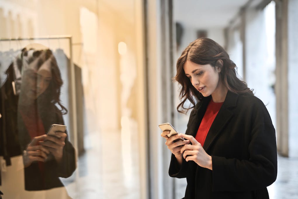 Woman using smartphone to read business reviews on Google Maps