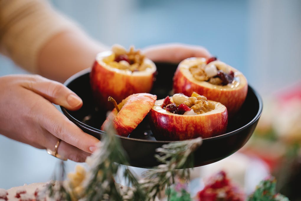 Crop chef with tasty stuffed baked apples during Christmas holiday
